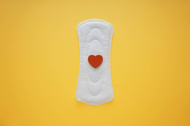 Menstrual pad with red heart on color background - Photo, Image