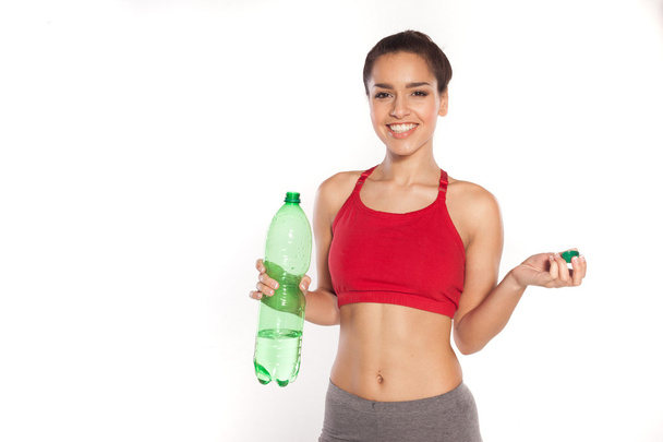Усміхнена молода жінка з пляшкою води
 - Фото, зображення
