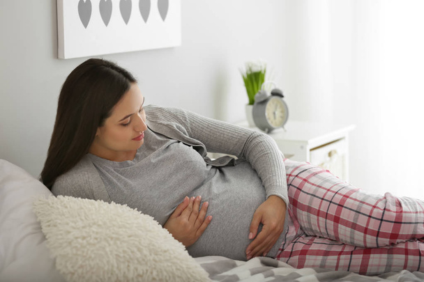 Όμορφη έγκυος γυναίκα ανάπαυσης στο υπνοδωμάτιο - Φωτογραφία, εικόνα