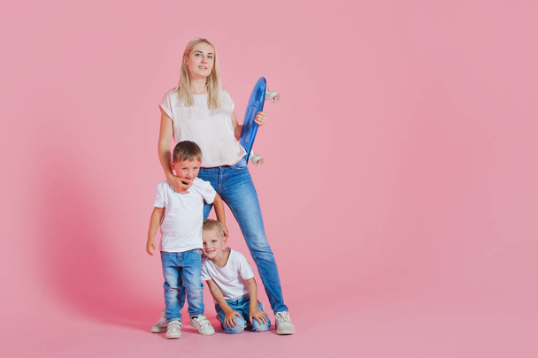Beautiful blonde mom with two happy sons. Young woman and two baby boys - Фото, изображение