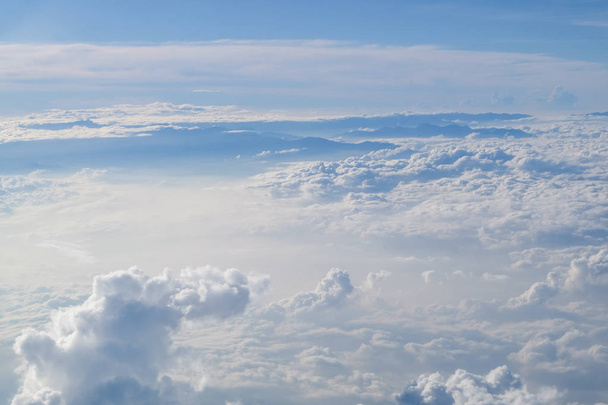 Güneşli mavi gökyüzü arka plan üzerinde bir uçak penceresinden kümülüs cennet görünümü. - Fotoğraf, Görsel