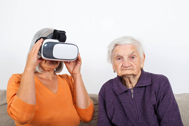 ヘッドセットと仮想現実ビデオを経験している高齢の女性 - 写真・画像