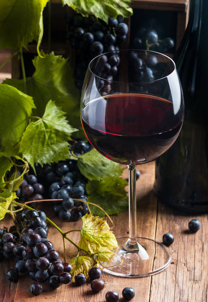 Vin rouge et raisins dans un cadre vintage sur fond de bois
 - Photo, image