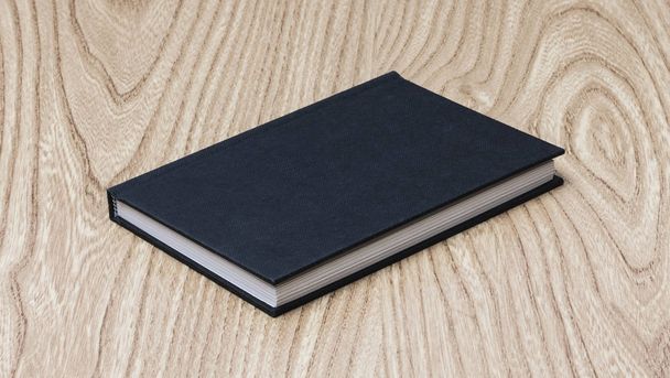 Black book on wooden table - Фото, зображення