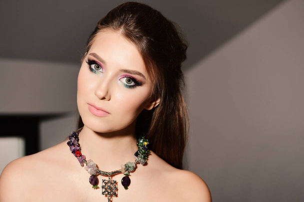 Style and fashion concept: girl wearing colourful makeup and necklace - Foto, Imagen