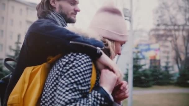 Slow motion happy relaxed young romantic couple walk together hugging, holding hands and smiling on a snowy winter day. - Filmagem, Vídeo