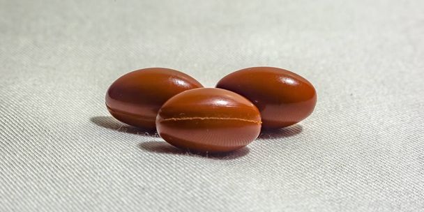 Group of orange pills on fabric textured surface - Photo, Image