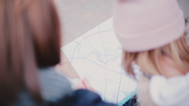 観光人および都市地図を見て女性のハイアングル ショット旅行ガイド一緒に冬の日のクローズ アップの背面図. - 映像、動画