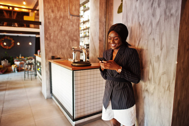 African american businesswoman in cafe with mobile phone. Black girl having rest. - Foto, afbeelding