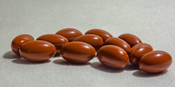 Oranžové pilulky na tkanině texturou bílé pozadí - Fotografie, Obrázek