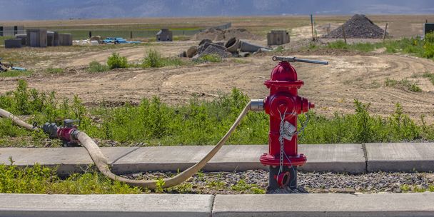 Hidrante de fuego rojo con manguera conectada y llave inglesa
 - Foto, Imagen