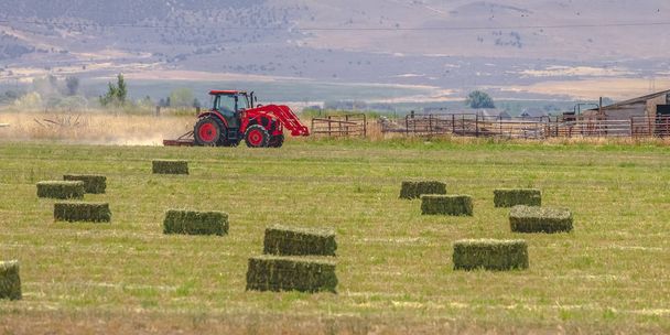 Czerwony traktor i starej stodole na polu w Utah Valley - Zdjęcie, obraz