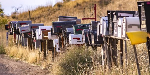 Fila de caixas de correio em uma estrada gramada
 - Foto, Imagem