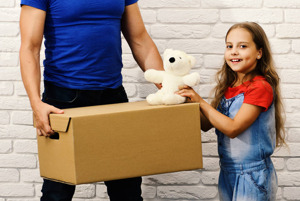 Parent and child with cardboard box and teddy bear indoor - Foto, immagini