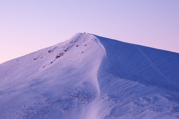 Hämmästyttävä auringonnousu vuorilla talvella. Lumen peitossa huiput vuorten säteet auringonnousun talvella pakkasaamuna
. - Valokuva, kuva