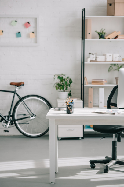bicycle, shelves and table in modern business office - Фото, изображение