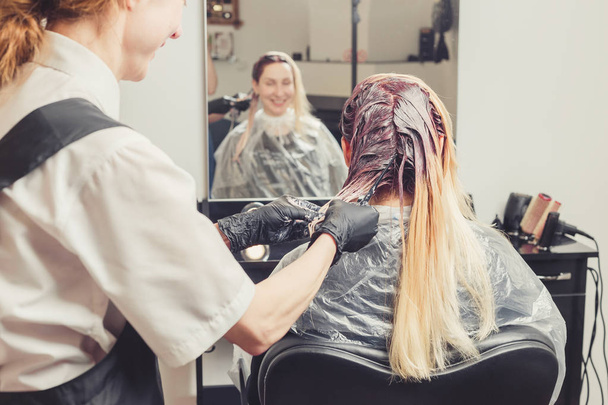Kobiece stylista nałożenie farby do włosów klientów w salonie kosmetycznym - Zdjęcie, obraz