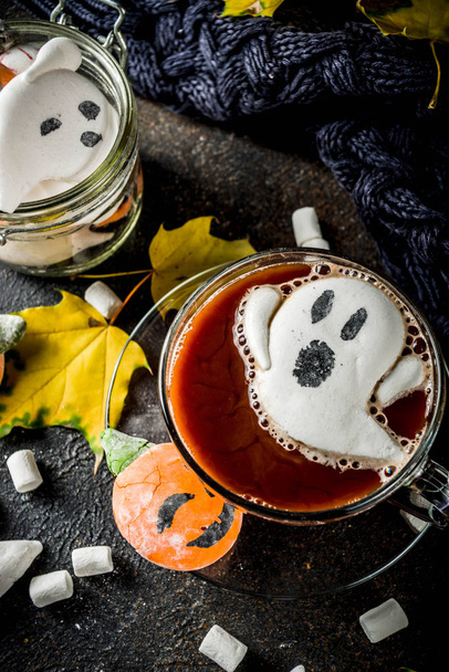 Grappig idee voor Halloween party, warme chocolademelk met decoratieve met marshmallows in de vorm van een spook, pompoen, monster, ogen, donkere achtergrond kopiëren ruimte - Foto, afbeelding