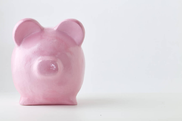 Vaaleanpunainen säästöpossu valkoisella taustalla. Rahoitus, säästää rahaa, luonnollisessa tilassa
 - Valokuva, kuva