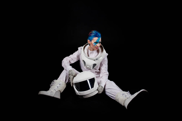 Astronaut on a black background, a young woman with face art in the space suit. - Foto, Imagen