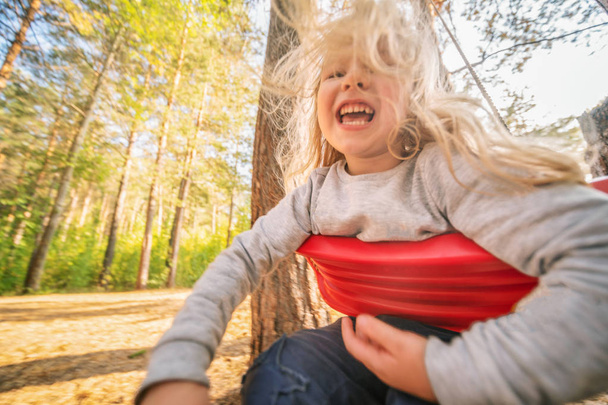 Little girl having fun on a swing outdoor - Foto, Bild