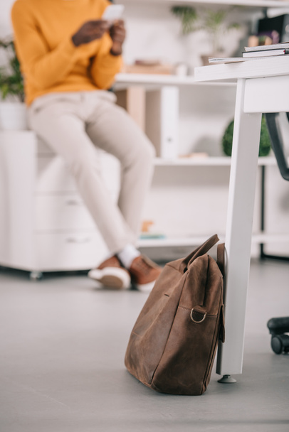 selective focus of leather bag and manager in modern office  - Foto, Bild