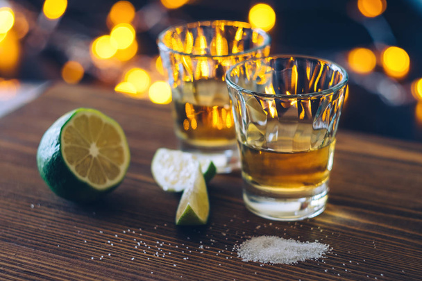 Shot of tequila with lime and salt on bokeh background. - Photo, Image