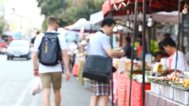 Mercado callejero de alimentos en Asia. Comida asiática. Resumen borroso turista compra comida callejera asiática
 - Metraje, vídeo