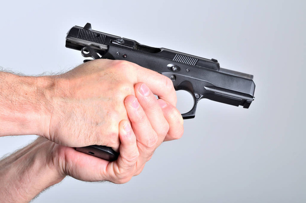 Hand van man met een pistool - zijaanzicht - Foto, afbeelding