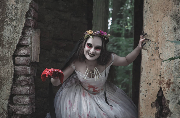 Strašidelná mrtvá nevěsta s krvavým masem v ruce. Halloween scéna  - Fotografie, Obrázek