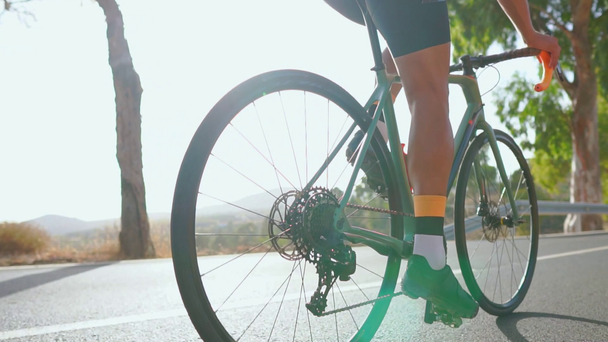 Ο άνθρωπος Ποδηλασία δρόμου ποδήλατο υπαίθρια άσκηση σε ένα άδειο δρόμο το πρωί. Ακραίο άθλημα έννοια. Close - up, αργή κίνηση - Πλάνα, βίντεο