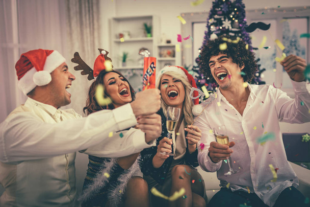 Kaksi nuorta iloinen parit juhlivat joulua konfetti kotona
 - Valokuva, kuva