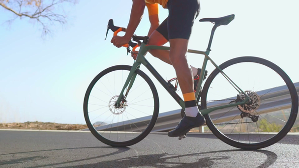 Man fietsen op de weg fiets buiten oefening op een lege weg in de ochtend. Extreme sport concept. Close - up, slow-motion - Video