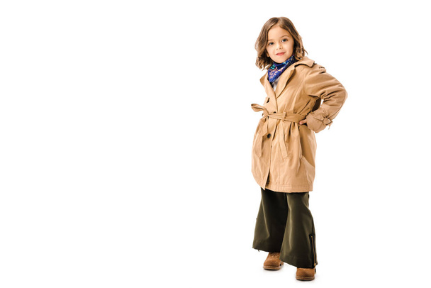 stylish little child in trench coat looking at camera isolated on white - Fotó, kép
