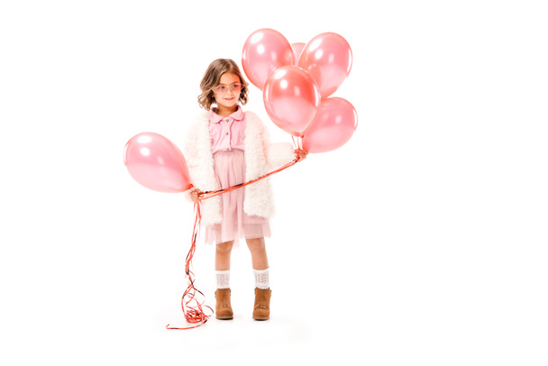stylish little child in fur coat with pink air balloons isolated on white - Photo, image