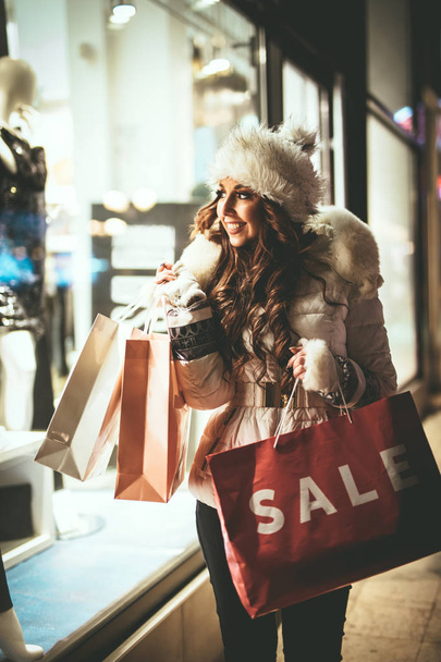 Молодая женщина с красочными сумки для покупок весело провести время на улице города на Рождество
 - Фото, изображение