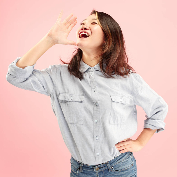 Isolated on pink young casual woman shouting at studio - Photo, Image