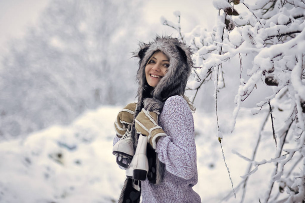 Happy woman smile with figure skates at trees in snow - 写真・画像