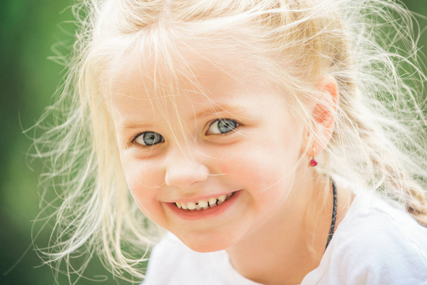 Doing hair. Small child happy smiling. Little girl wear hair in plaits. Small girl with blond hair. Happy little child with cute smile. Be positive and happy - Photo, image