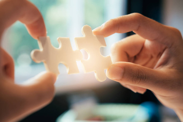Businessman hand connecting jigsaw puzzle. Business solutions, success and strategy and teamwork concept - Photo, Image