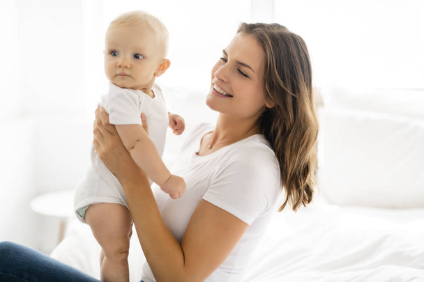 mother with baby on bed having good time - Photo, Image