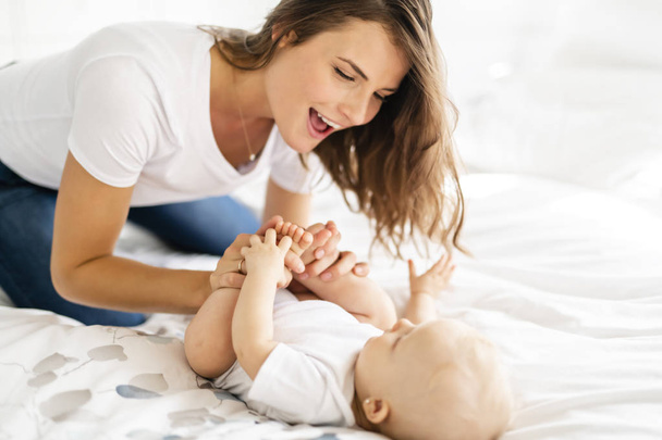 mother with baby on bed having good time - Fotoğraf, Görsel