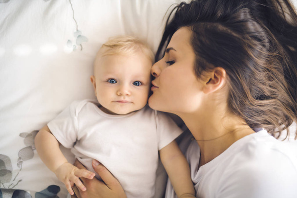 mother with baby on bed having good time - Photo, image