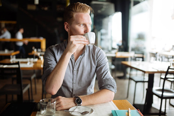 Businessman enjoying coffee during break - Foto, afbeelding