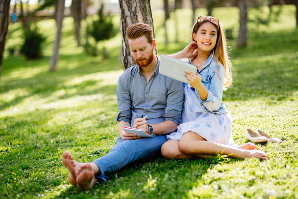 Beautiful college students flirting in park while studying - Foto, Imagem