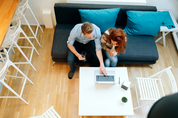 Couple working together in beautiful living room with laptop on desk - Photo, image