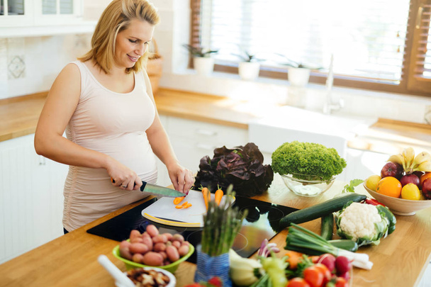Pregnant woman eating healthy  preparing meal from fresh ingredients - Foto, imagen