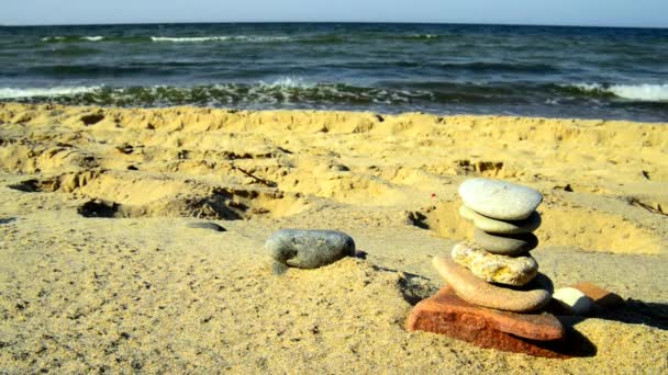 Pirâmide de pedra zen em uma praia com surf
 - Filmagem, Vídeo