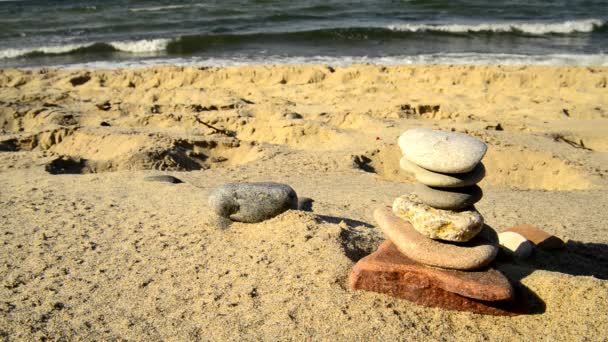 Zen-Steinpyramide an einem Strand mit Brandung - Filmmaterial, Video
