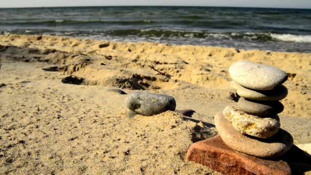 Ζεν πέτρα πυραμίδα σε μια παραλία με surf - Πλάνα, βίντεο
